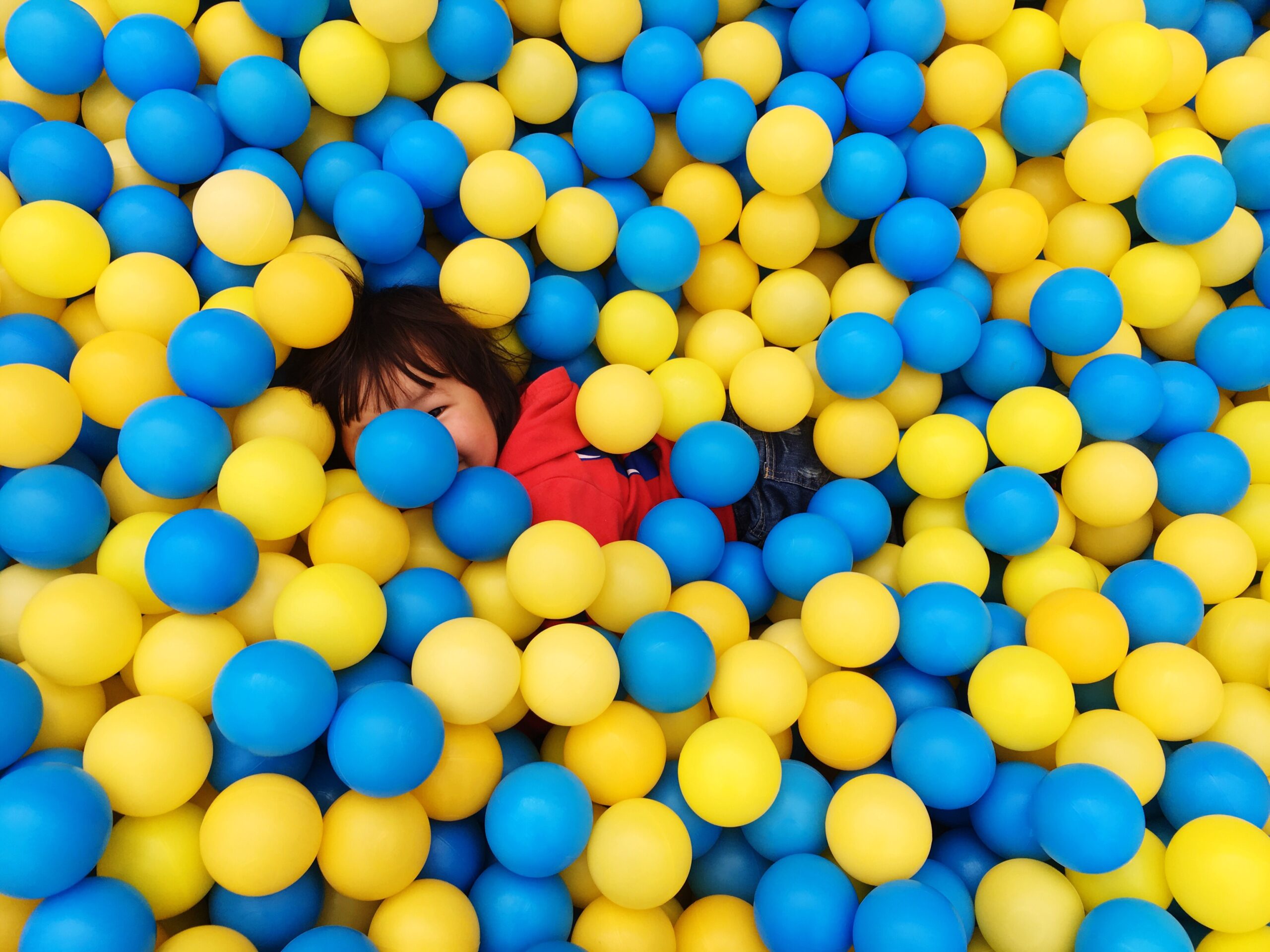 Parque de bolas, niño jugando, niña feliz, bolas de colores